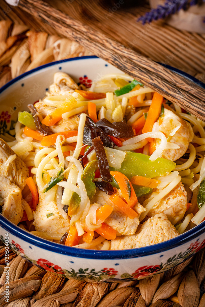 Poster fried noodles with chicken and vegetables.