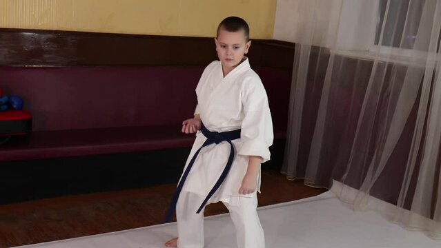 Athlete with blue belt training formal karate exercises