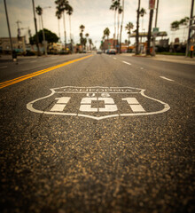 Highway 101 sign painted on the black asphalt road with city diffused in the background. The shot...