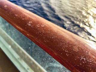 Dried salt from evaporated sea water on the handrail of a cruise ship