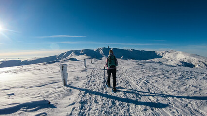 Woman in snowshoes on the way to majestic summit peak Grosser Speikogel in Kor Alps, Lavanttal...