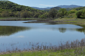 lake with green hills and mountains during summer