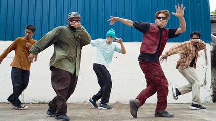 Group of hip hop choreographer dancing street dance together at wall. Young break dancer practicing break dance, moving to modern rhythm, express feeling of lively. Outdoor 2024. Endeavor. - obrazy, fototapety, plakaty