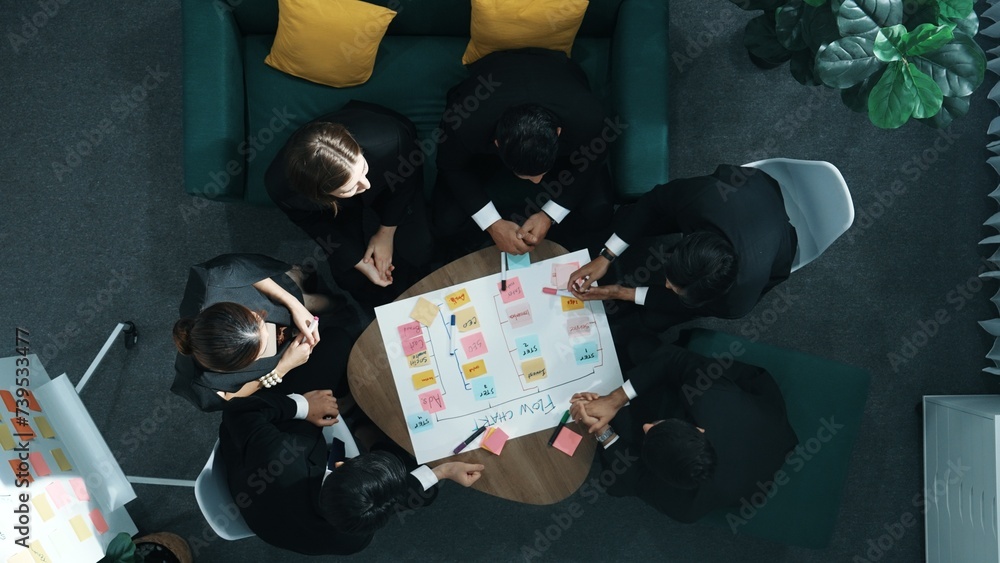 Poster close up of professional business team hands writing and putting sticky note on scrum task board. to