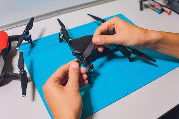 Closeup shot of man working on assembling new surveillance system using quadcopter drone with...