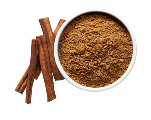 cinnamon sticks and  ceramic bowl with cinnamon powder isolated on a white background, top view.