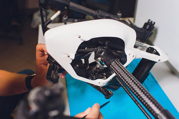 Closeup shot of man working on assembling new surveillance system using quadcopter drone with...