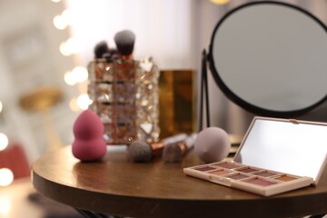 Obraz na płótnie Canvas Different beauty products and mirror on wooden table in makeup room, closeup