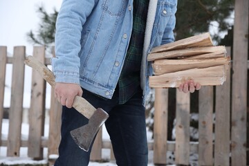 Man with axe and wood outdoors on winter day, closeup