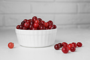 Ripe cranberries in bowl on white table