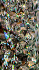 Air pockets suspended in a stream of water from my kitchen faucet.  An aerating water spigot produces small air bubbles in the water to make water flow see stronger.  Freeze Frame of Water.
