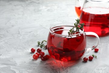 Delicious cranberry tea with thyme and berries on grey table, closeup. Space for text