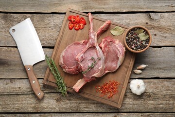 Fresh tomahawk beef cuts, butcher knife and spices on wooden table, top view