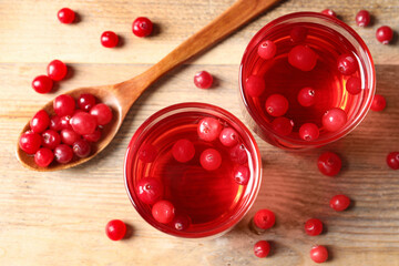 Tasty cranberry juice in glasses and fresh berries on wooden table, flat lay