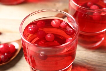 Tasty cranberry juice in glasses and fresh berries on wooden table, closeup