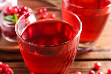Tasty cranberry juice in glasses on table, closeup