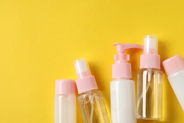 Cosmetic travel kit on yellow background, flat lay. Space for text