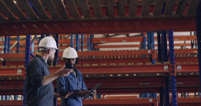Warehouse, inspection and people with tablet in factory check inventory, storage and planning construction. Industrial, discussion and discuss checklist in report of safety maintenance and compliance