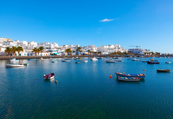 Awesome blue lagoon in Arrecife Lanzarote, Canary Islands Spain. Moored fishing boats on Atlantic bay