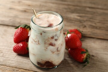 Tasty yoghurt with jam and strawberries on wooden table, closeup