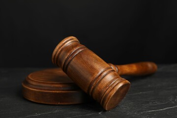 Wooden gavel on dark textured table, closeup