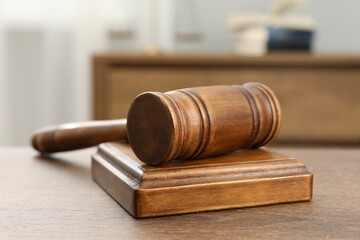 Wooden gavel and sound block on table indoors, closeup