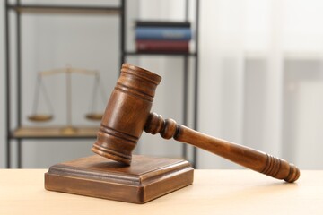 Wooden gavel and sound block on table indoors, closeup