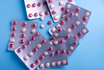 Close up of a colorful pills.bicolor pills wrapped in the blister. Three tablets out of the blister.