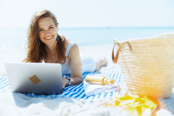 happy modern woman on seashore with straw bag