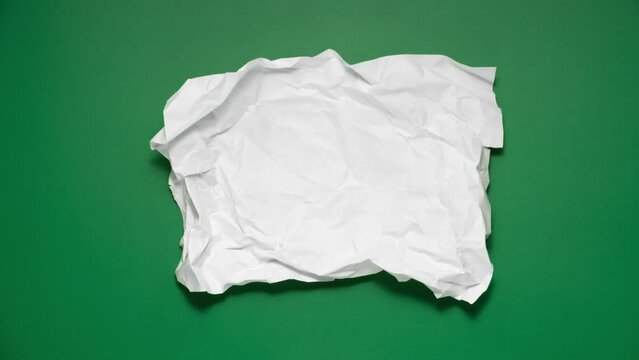 Stop motion animation of crumpled pape on a green background.