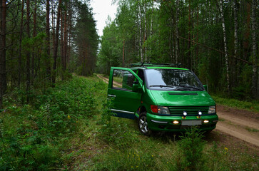 A green car on a forest road