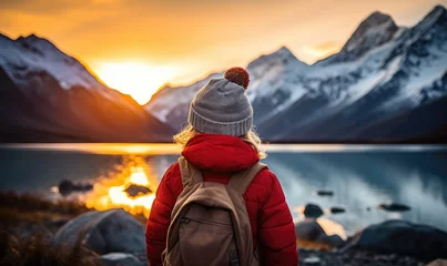 Fototapete Aoraki/Mount Cook Winter Wonderland Expedition: A Happy Tourist Woman, Back View, Immerses Herself in the Tranquility of a Glacier Lake, Aoraki/Mount Cook, and the Southern Alps under the Majestic Sunset Sky in Winter