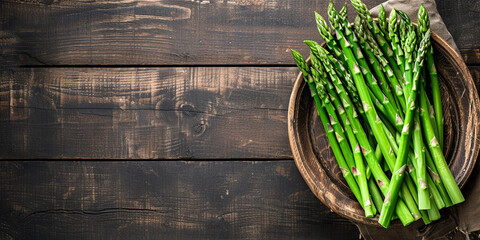 The photo shows fresh green asparagus on a wooden cutting board in a rustic style.
