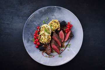 Traditionally roasted saddle of venison fillet with South Tyrolean bread dumplings, redcurrants and...