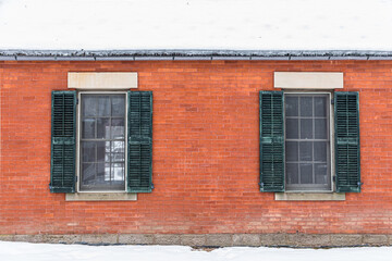 Old brick building with weathered green shutters