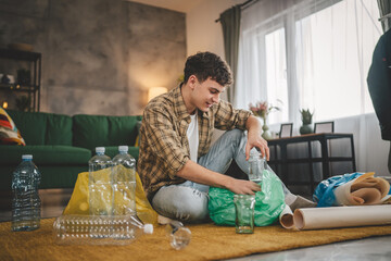 one man young adult recycle at home sort waste plastic paper and glass