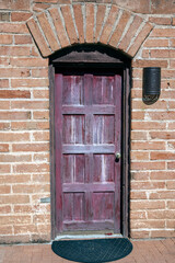 old weathered wooden door in brick wall
