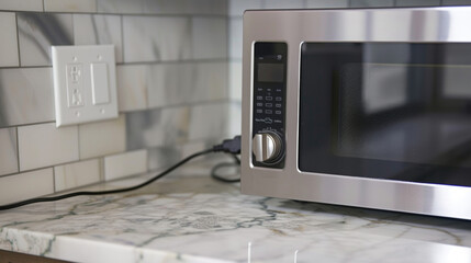 Detailed image of the microwaves power cord plugged into a nearby outlet.