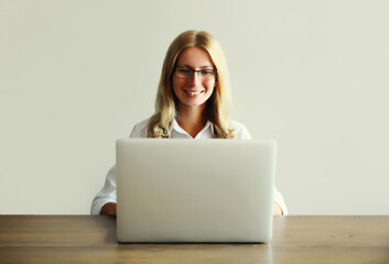 Naklejka premium Happy woman working with laptop sitting at desk in office or home