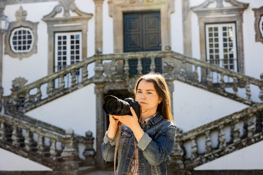 Interested woman photographer taking pictures of scenic view of Mateus palace, Vila Real, Portugal