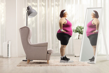 Corpulent woman wearing sportswear and standing in front of a mirror on a weight scale