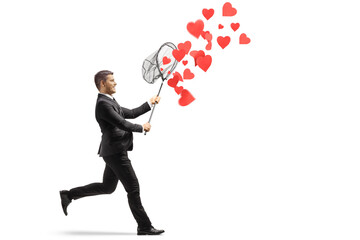 Man in a black suit running and catching hearts with a net