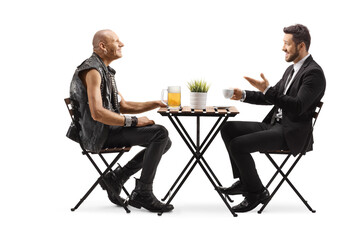 Obraz premium Punk with a pint of beer at a cafe and a businessman with a cup of coffee