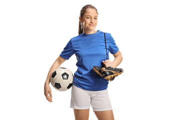 Teenage female football player holding a soccer ball and cleats