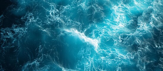 An aerial view of a vast body of fluid, with wind waves creating a pattern on the electric blue water, along with underwater reefs supporting marine biology - obrazy, fototapety, plakaty