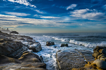 Obraz premium 2022-01-14 THE ROCKY COASTLINE WITH WAVES APPROACHING AND A GRASS HUT AT THE WINDANSEA BEACH IN LA JOLLA CALIFORNIA NEAR SAN DIEGO