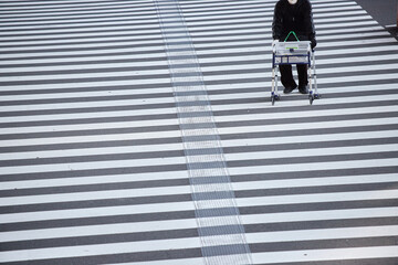 冬の昼の街の道で歩く障害者のシニア男性の姿