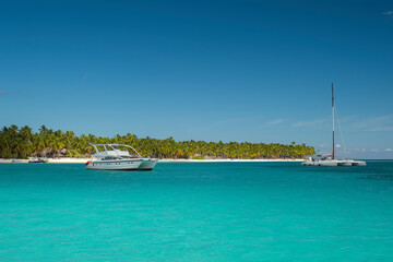 Seascape with crystal clear shallow turquoise ocean water, deep blue sky and white yachts and boats...