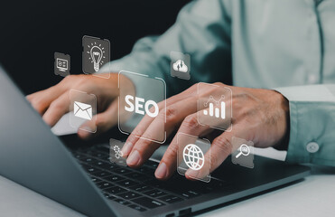 Hands typing on a laptop, with translucent SEO and digital marketing icons floating above, symbolizing online strategy planning. Search Engine Optimization Marketing Website Internet Technology.