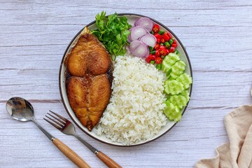 Fried fish with rice and thai style chill sauce with vegetables,top view food